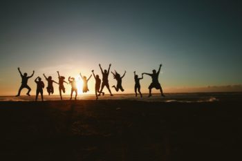 people jumping in the air on a beach