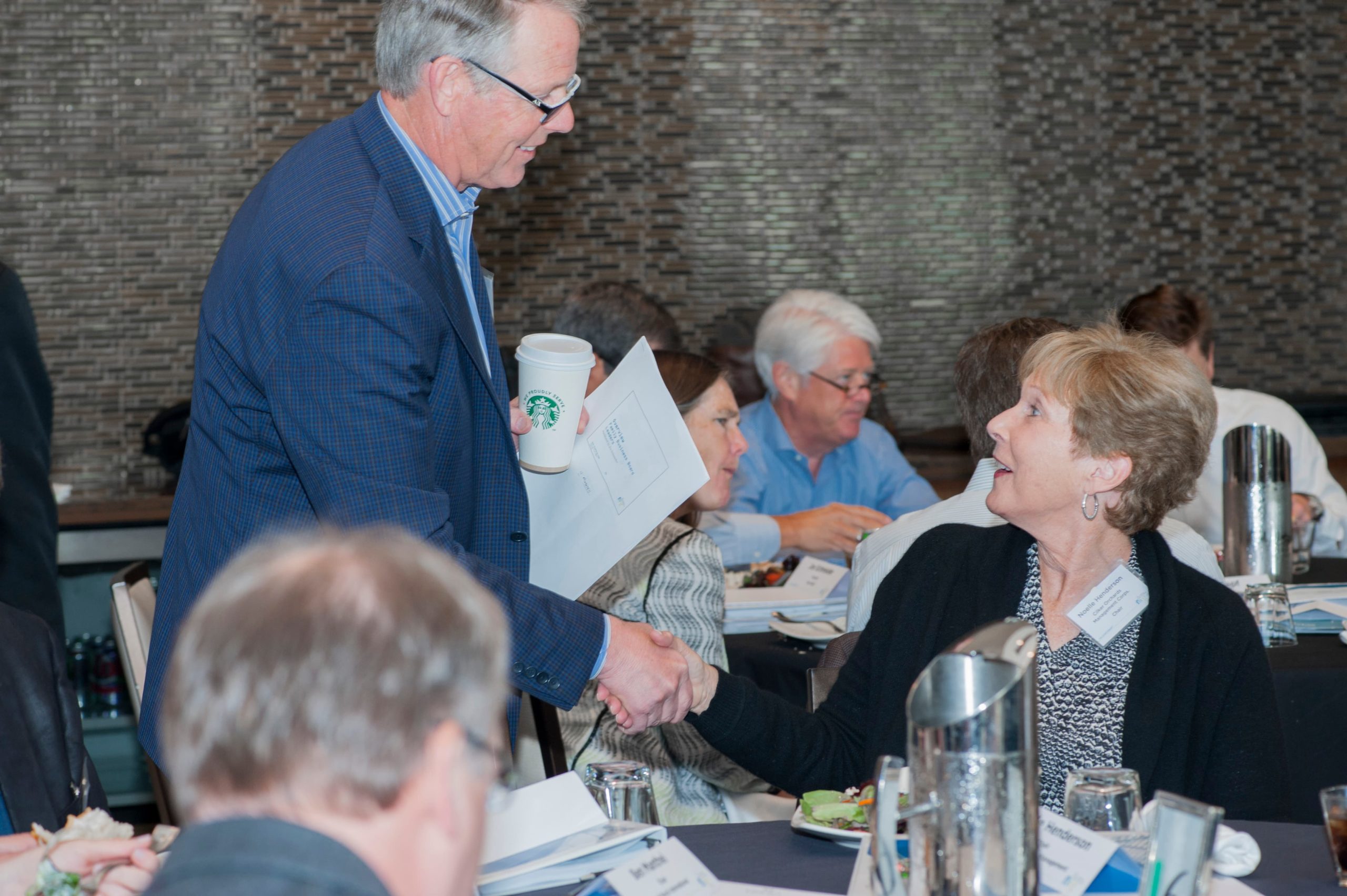 two people shaking hands at a conference