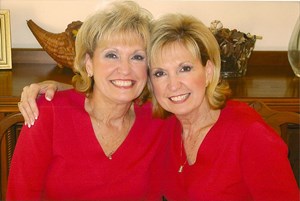 two women wearing red smiling