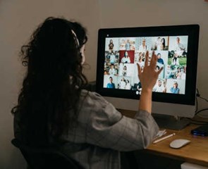 woman sitting in front of a zoom call with her coworkers