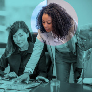 Middle aged businesspeople sitting in office pointing at papers