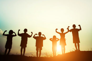 silhouette of six children playing at sunset