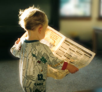 child reading a newspaper