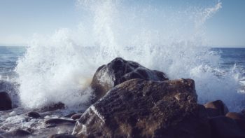 water crashing onto rocks at the lake