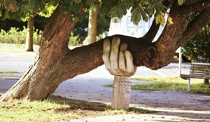 escultura de mano que sostiene un árbol